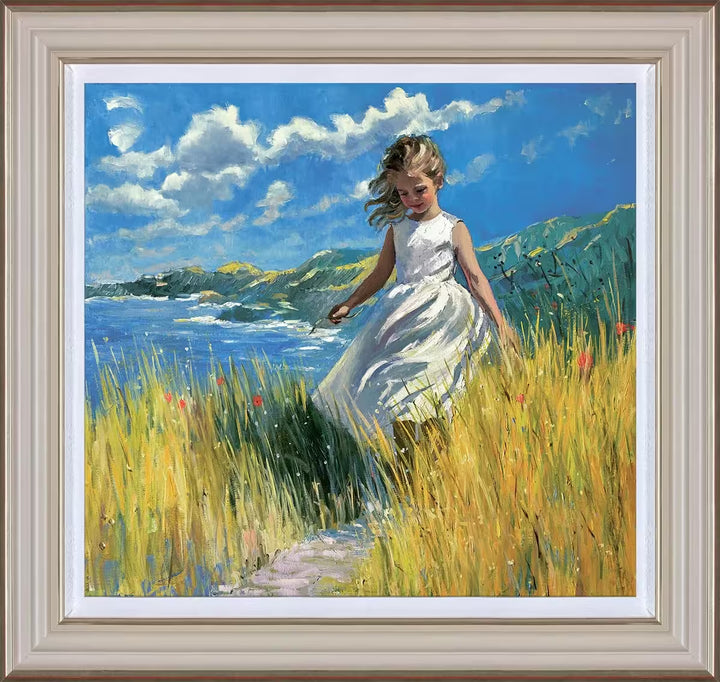 A Sherree Valentine Daines framed limited edition of a girl in a white dress walking through tall grass and flowers, the title is A Coastline Stroll