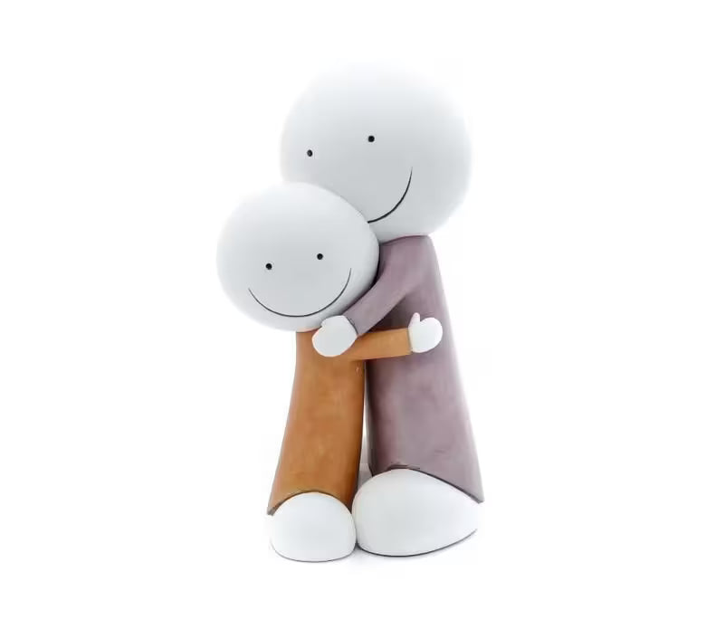 A sculpture by Doug Hyde of one person in orange hugging a larger person in purple, the title is Big Hugs