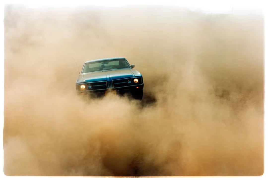 A limited edition photograph by Richard Heeps using vibrant colours, the title is Buick In The Dust II, Hemsby, Norfolk, 2000
