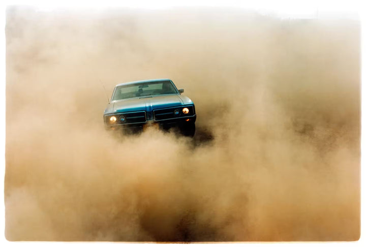 A limited edition photograph by Richard Heeps using vibrant colours, the title is Buick In The Dust II, Hemsby, Norfolk, 2000