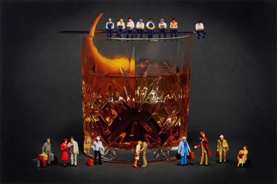 A Mr Kuu limited edition of a glass of whiskey with workers sat on the top and people all around the glass, the title is Call Me Old Fashioned
