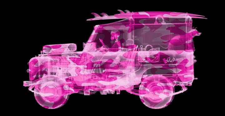 A limited edition Chromaluxe print by Nick Veasey of an X-Rayed vehicle with a skeleton person sat in the front and a skeleton dog leaning out of the back of the car along with beach items scattered around the car, the title is Camouflage Land Rover Surfer- Pink