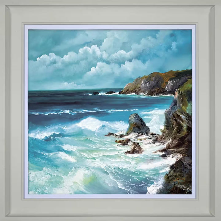 A Philip Gray framed limited edition of waves crashing against jagged rocks against a light blue cloudy sky, the title is Coastal Charm
