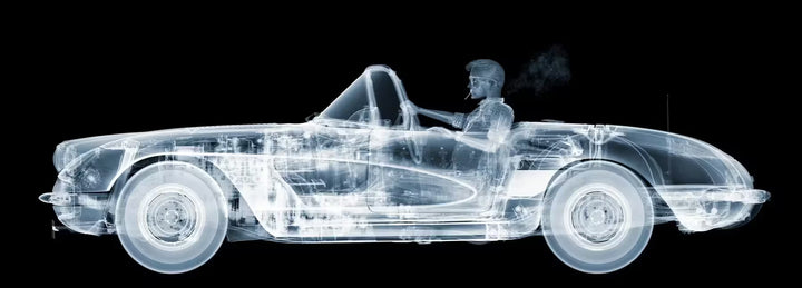 A limited edition Chromaluxe print by Nick Veasey of an X-Rayed vehicle with a skeleton sat in the front seat driving, the title is Corvette Cruiser