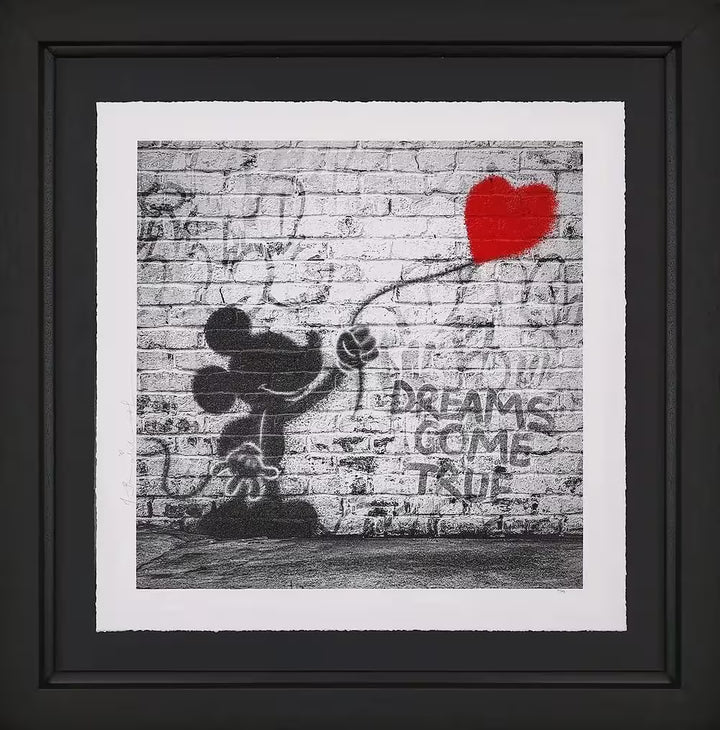 A Mr Brainwash framed limited edition of a grey wall with Mickey Mouse holding onto a red heart balloon spray painted onto it, the title is Dreams Come True