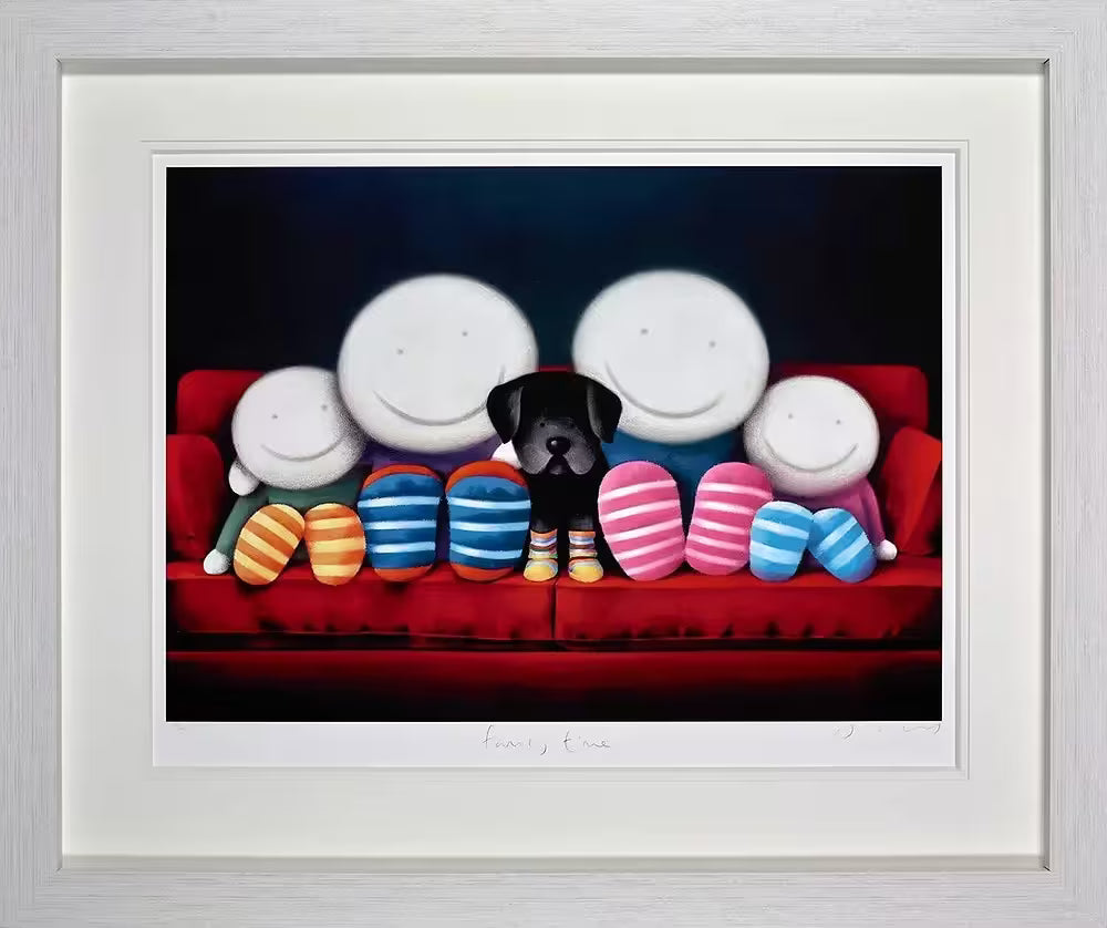 A framed Doug Hyde limited edition print of two adult and two children characters and a black dog sat on a red sofa all wearing striped socks, title is Family Time