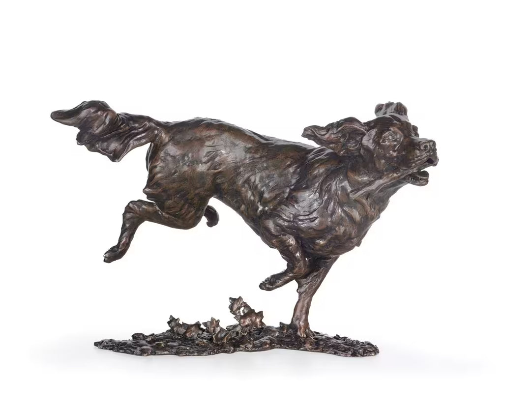 Bronze sculpture of a dog running with a smaller figure on a white background, Free Spirit by Dean Kendrick