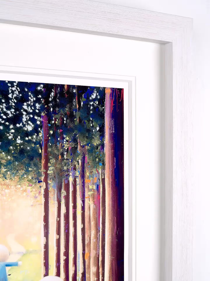 A Doug Hyde limited edition of two people riding bikes through a sunny forest, the title is Good Times Ahead
