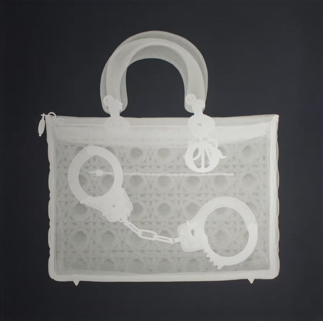 A limited edition Silkscreen print by Nick Veasey of an X-Rayed handbag with a pair of handcuffs inside, the title is Handucff Handbag
