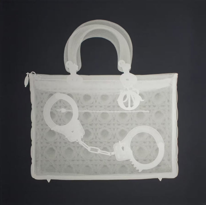 A limited edition Silkscreen print by Nick Veasey of an X-Rayed handbag with a pair of handcuffs inside, the title is Handucff Handbag