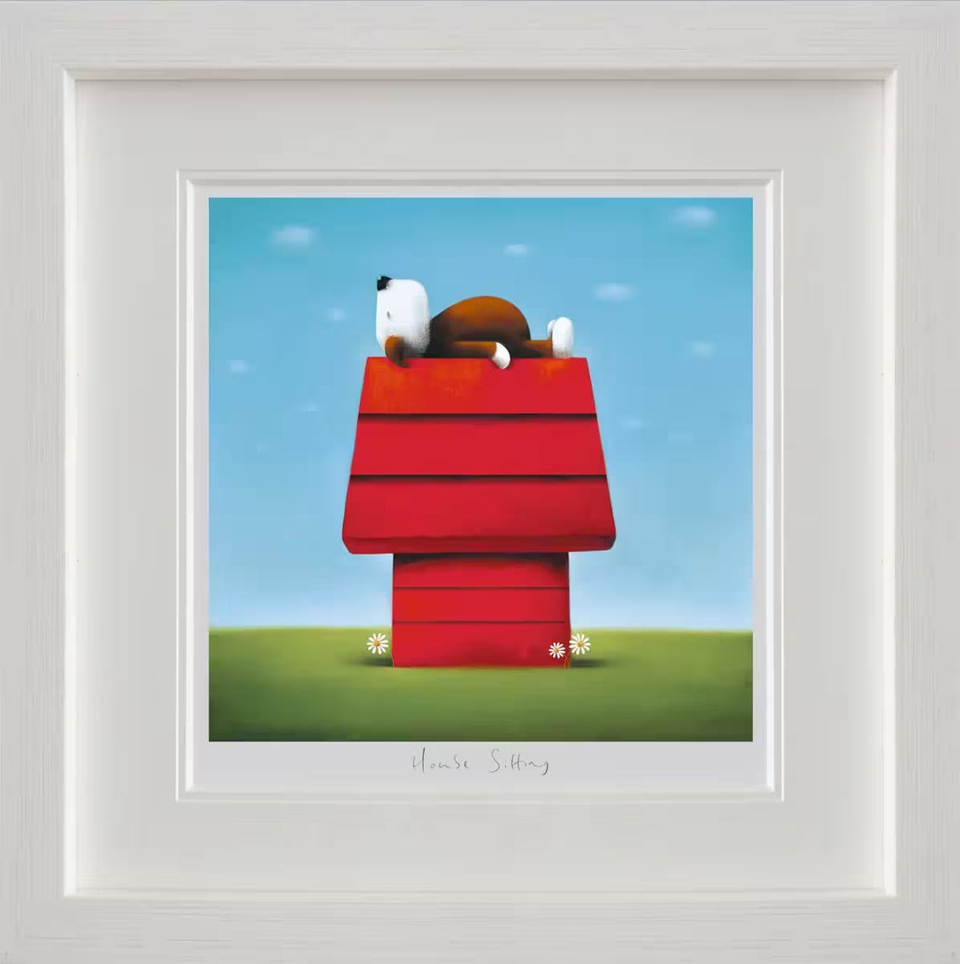A Doug Hyde framed limited edition print of a brown and white dog laying on it's back on top of a red dog house surrounded by some flowers, the title is House Sitting