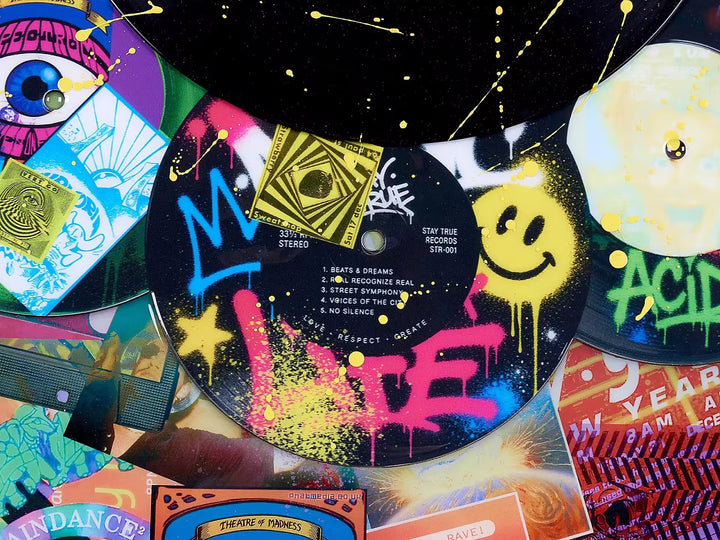 A limited edition mixed media piece by Dan Pearce of lots of differrent vinyl records with spraypaint and designs all over them, the title is In The Mix