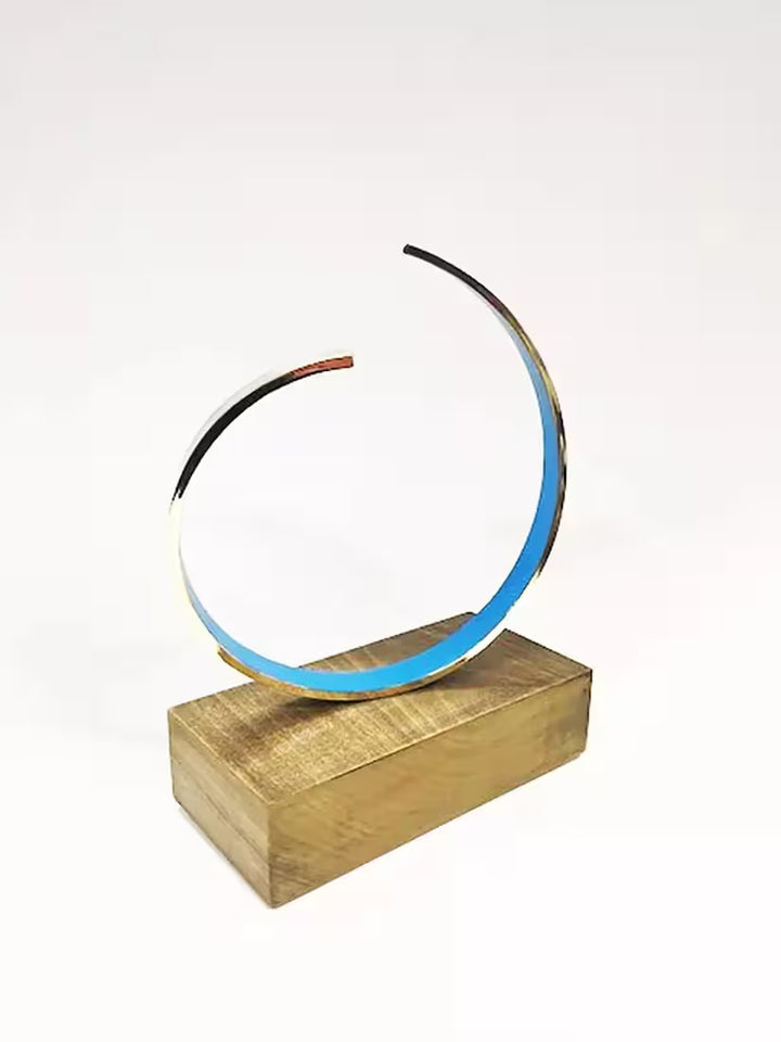 A Gareth Griffiths original sculpture of a blue spiral with a gold band around it, the title is La Onda