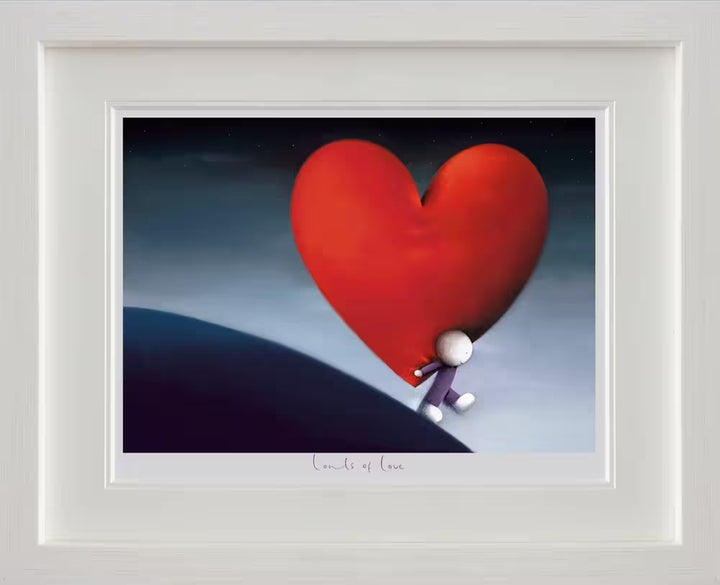 A Doug Hyde framed limited edition of a person in purple walking downhill carrying a giant red heart on their back, the title is Loads of Love