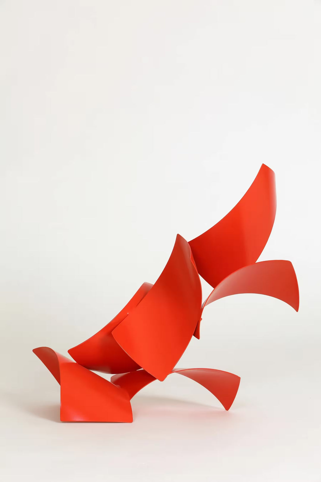 A Gareth Griffiths original sculpture of red geometric shapes arranged to make a slanted tower, the title is Los Brajas