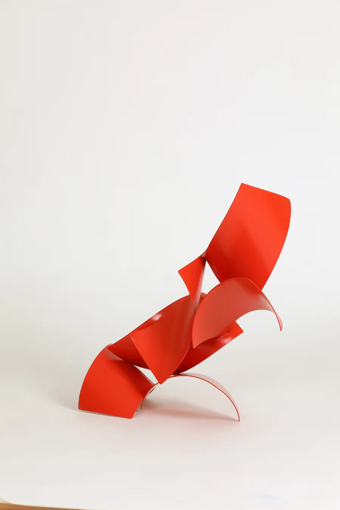 A Gareth Griffiths original sculpture of red geometric shapes arranged to make a slanted tower, the title is Los Brajas