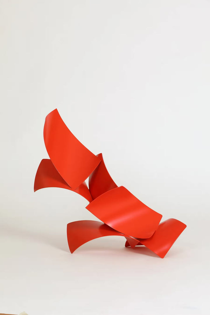 A Gareth Griffiths original sculpture of red geometric shapes arranged to make a slanted tower, the title is Los Brajas