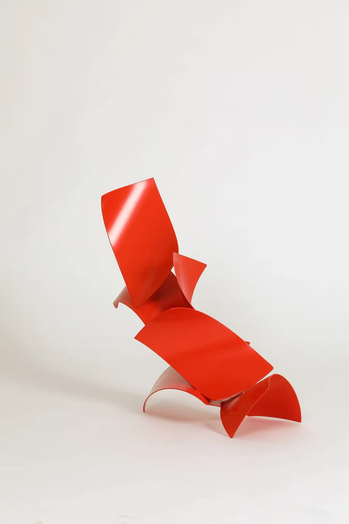 A Gareth Griffiths original sculpture of red geometric shapes arranged to make a slanted tower, the title is Los Brajas