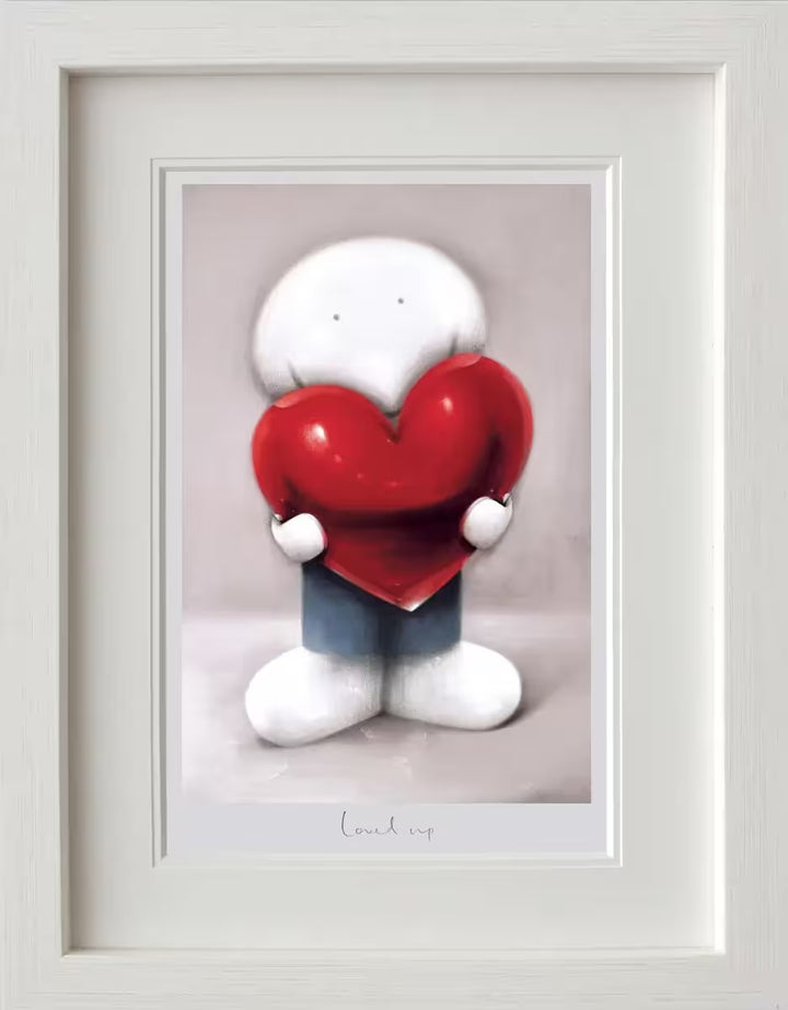 A Doug Hyde framed limited edition print of a person in blue holding a red heart, the title is Loved Up