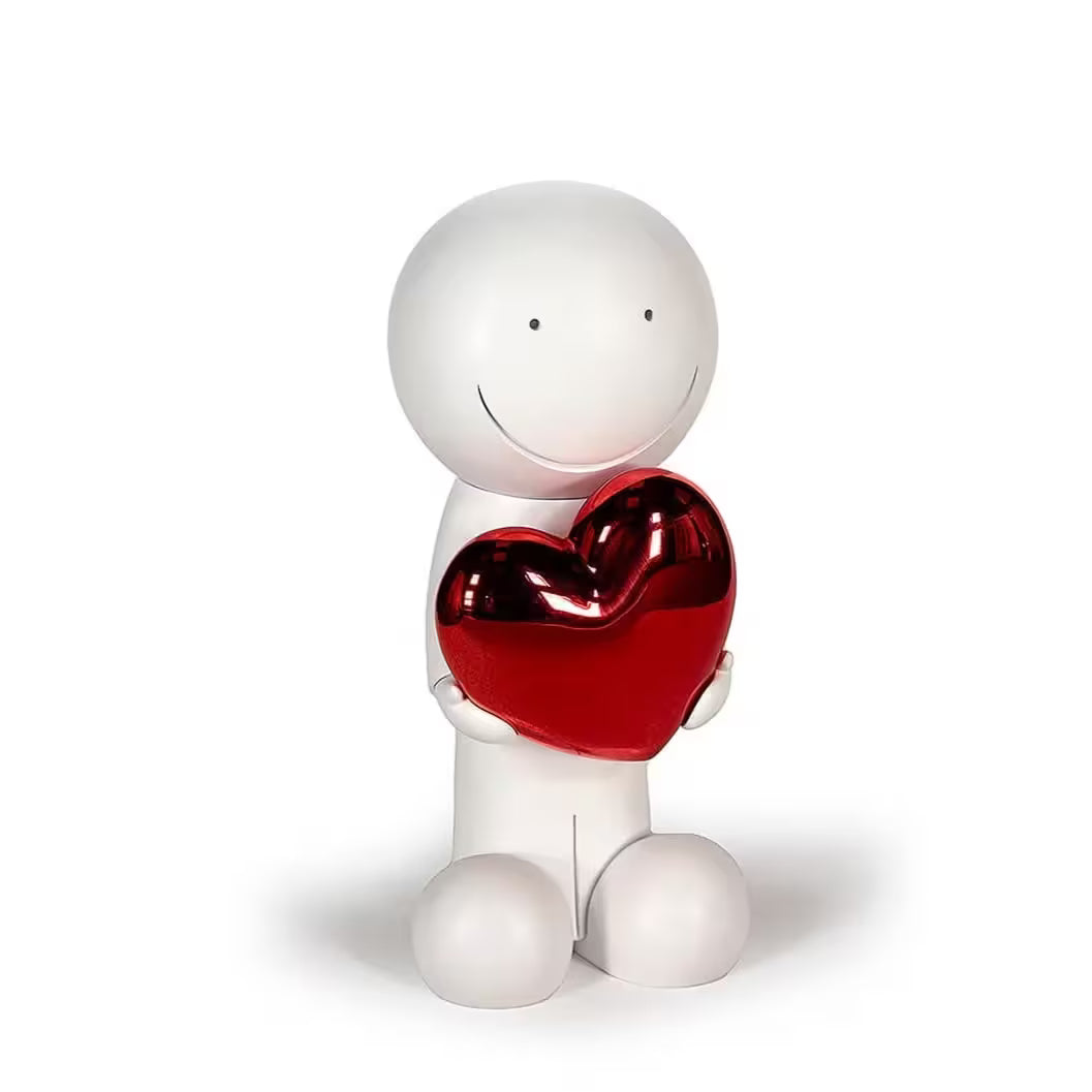 A sculpture by Doug Hyde of a person holding a heart in white and red, the title is One Love (White & Red)