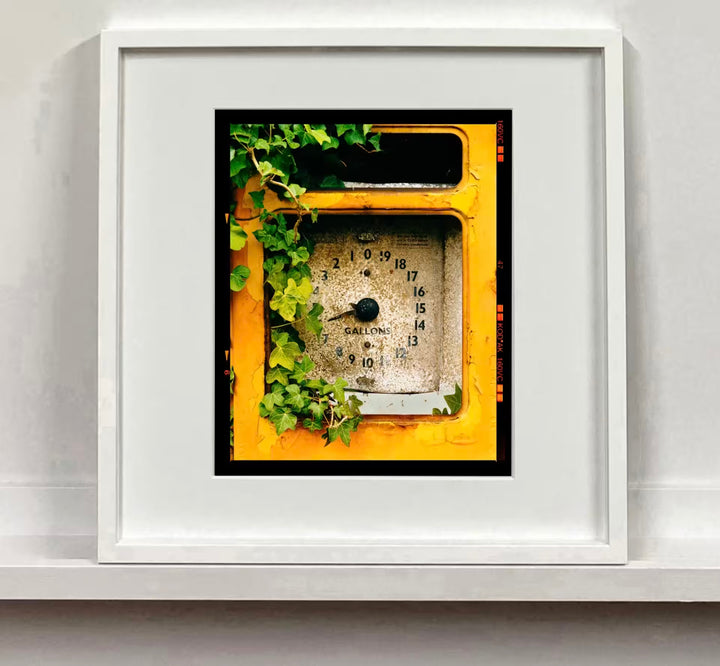 A white framed limited edition photograph by Richard Heeps using vibrant colours, the title is Petrol Pump, Stow Bardolph, Norfolk, 2005