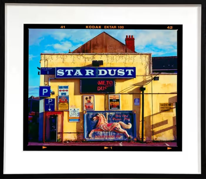 A framed limited edition photograph by Richard Heeps using vibrant colours, the title is Pleasure Park, Barry Island, 2023