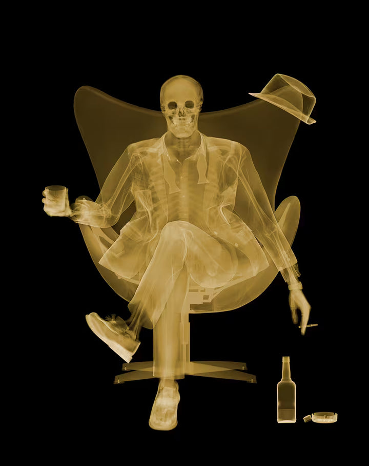 A Nick Veasey  limited edition Chromaluxe Xray of a person sat in a chair drinking and smoking, the title is Rat Pack- Golden Era
