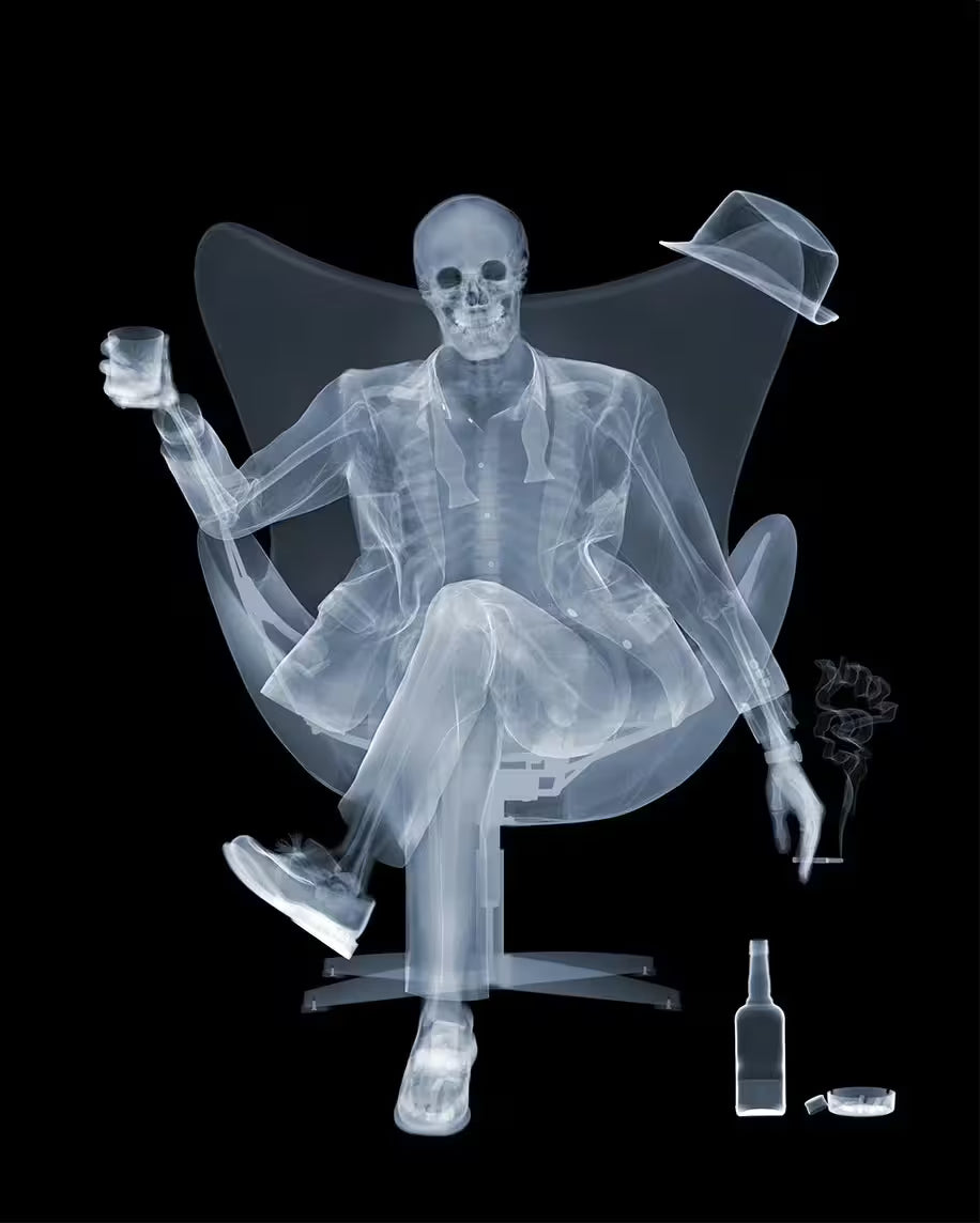 A limited edition lenticular print by Nick Veasey of an X-Rayed ratpack member sat on a big chair raising a drink, the title is Rat Pack Raising A Glass