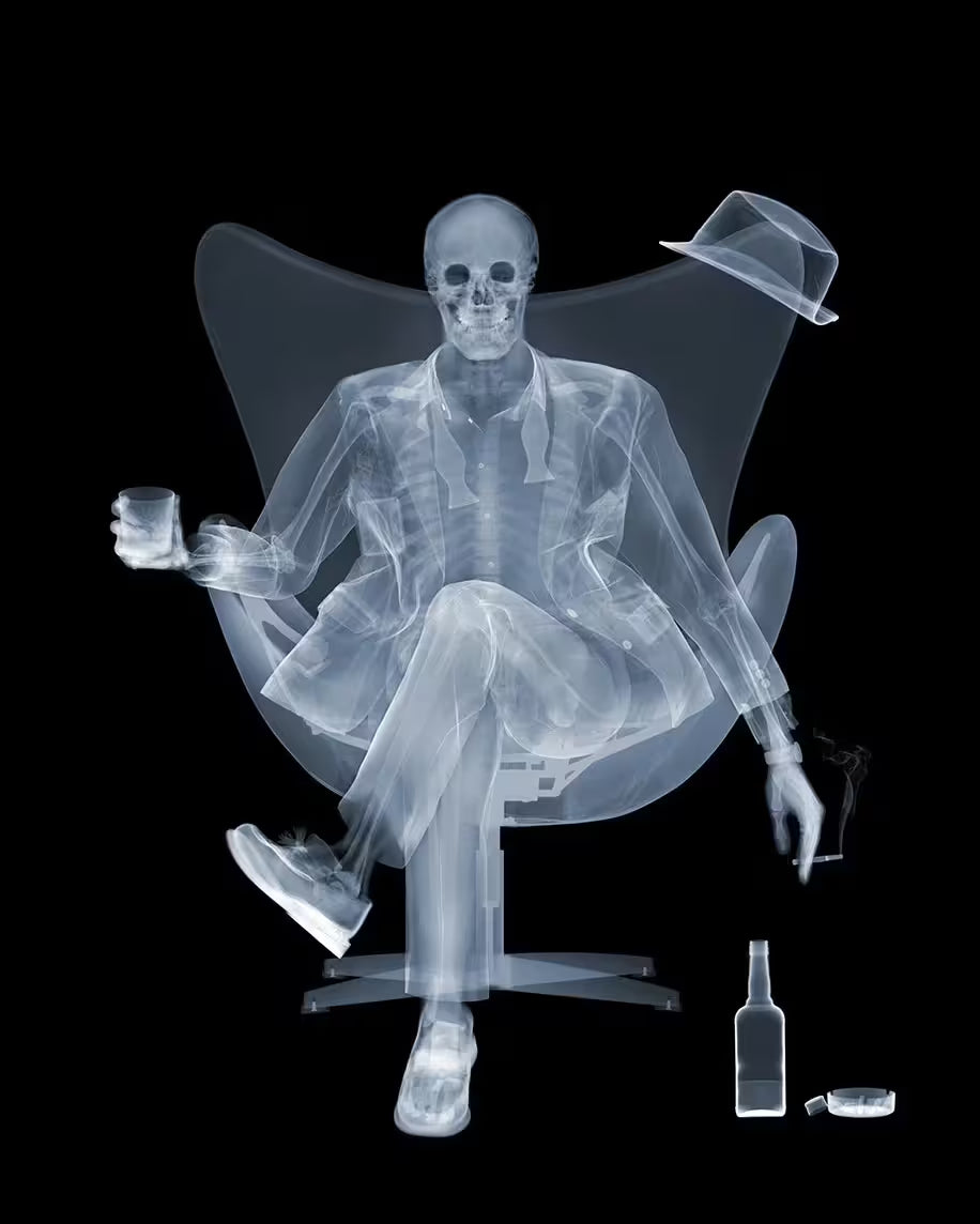 A limited edition lenticular print by Nick Veasey of an X-Rayed ratpack member sat on a big chair raising a drink, the title is Rat Pack Raising A Glass