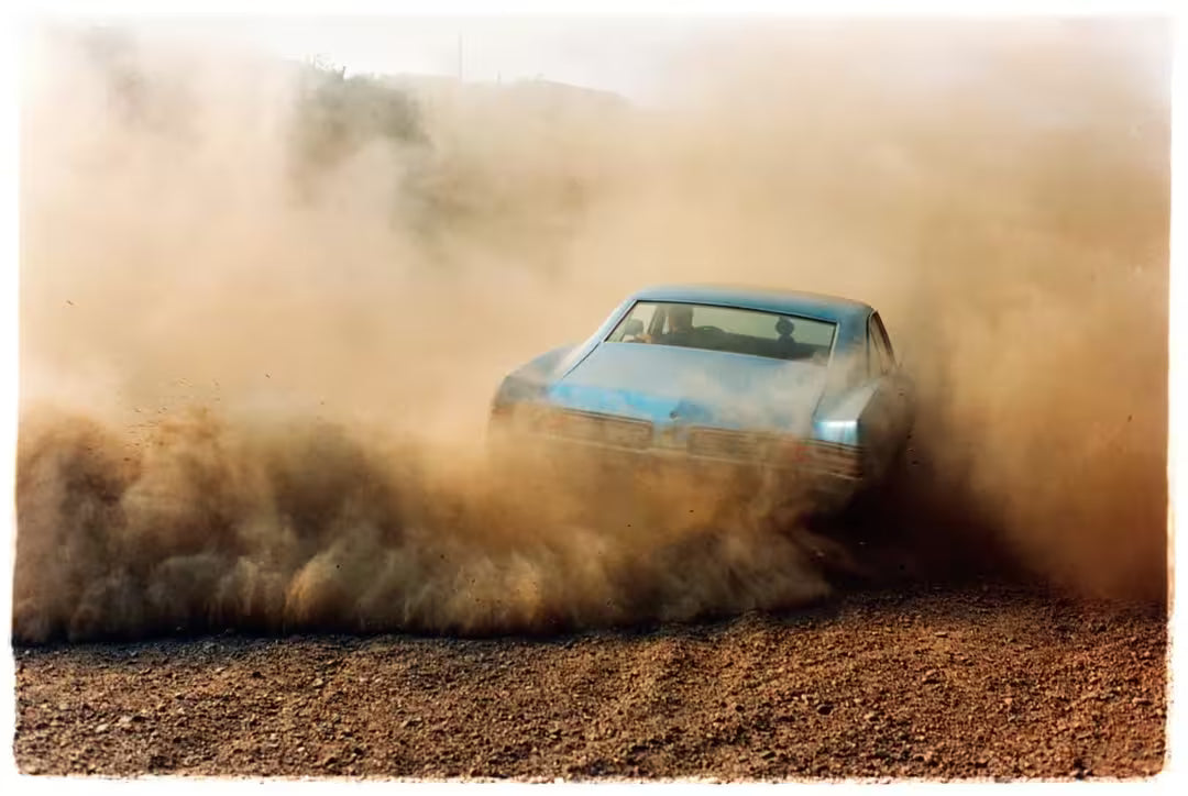 A limited edition photograph by Richard Heeps using vibrant colours, the title is Buick In The Dust III, Hemsby, Norfolk, 2000