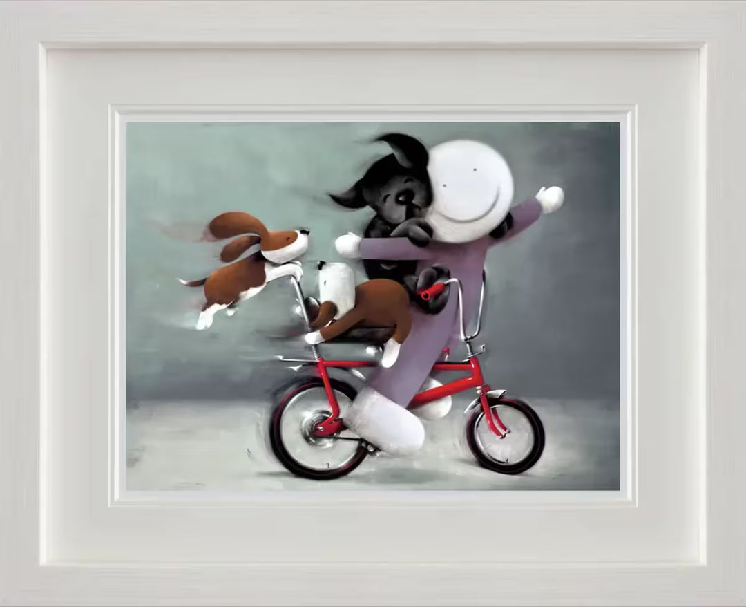 A Doug Hyde framed limited edition of a person in purple on a red bike with a black dog on their back and two brown dogs holding onto the bike, the title is Riding High