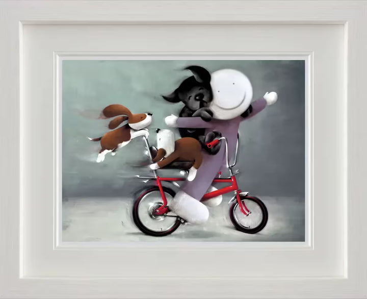 A Doug Hyde framed limited edition of a person in purple on a red bike with a black dog on their back and two brown dogs holding onto the bike, the title is Riding High