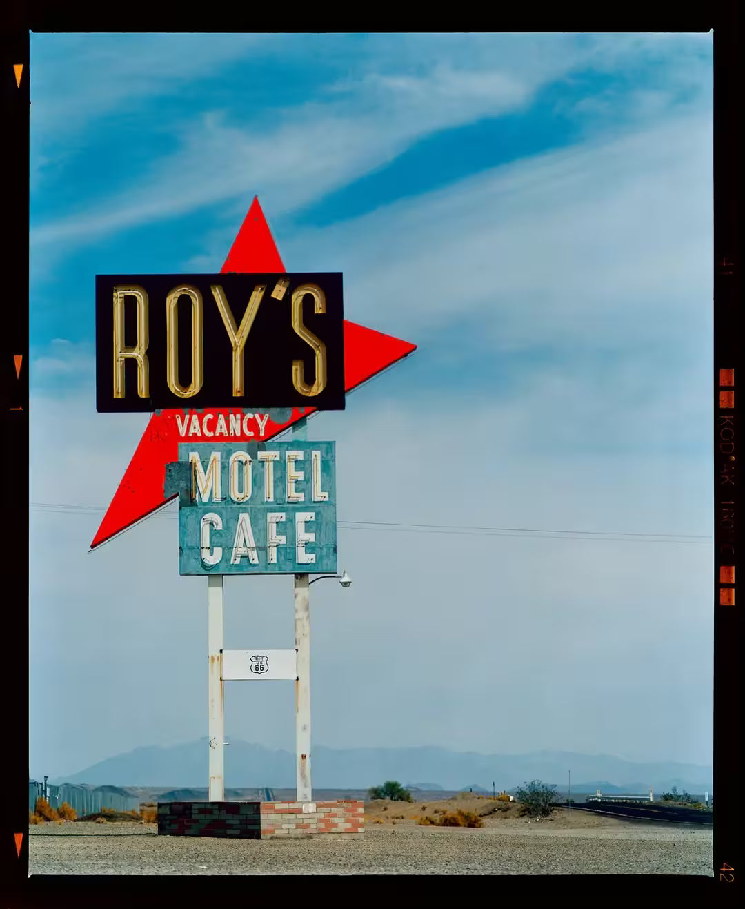 A limited edition photograph by Richard Heeps using vibrant colours, the title is Roy's Motel Sign, Amboy, California, 2002