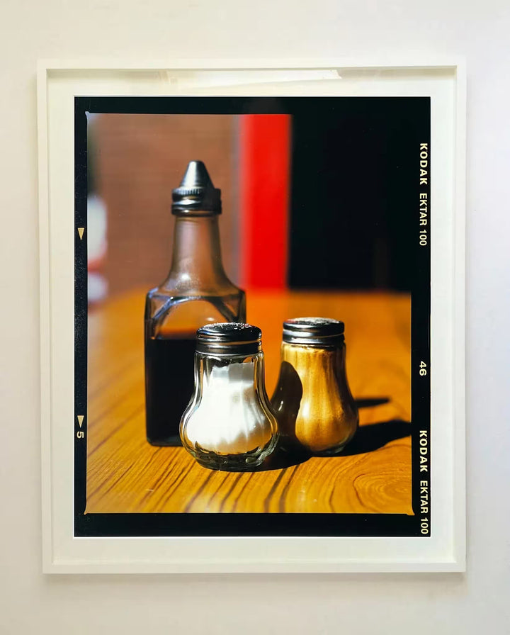 A white framed limited edition photograph by Richard Heeps using vibrant colours, the title is Salt, Pepper, and Vinegar, Clacton-On-Sea, 2021