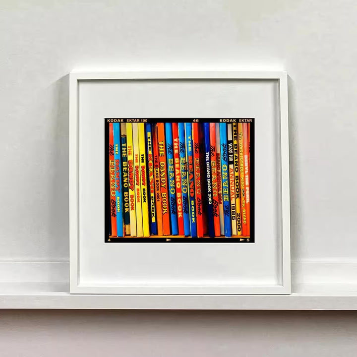 A white framed limited edition photograph by Richard Heeps using vibrant colours, the title is School Fun, Burnham Market, 2018
