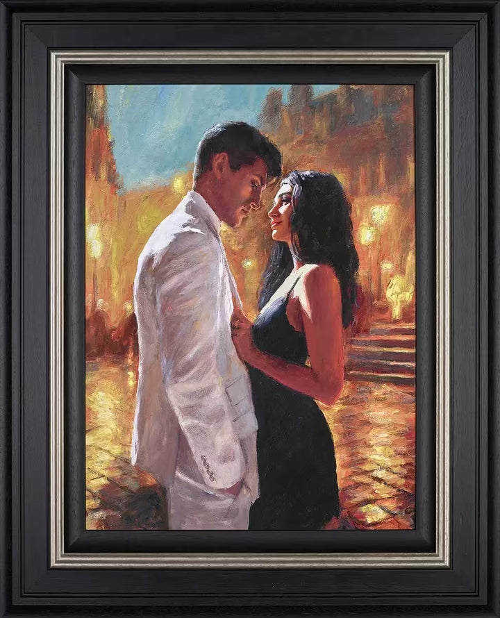A Fabian Perez framed limited edition of a man in a white suit and lady in a black dress stood in a warmly lit street, the title is Summer Love