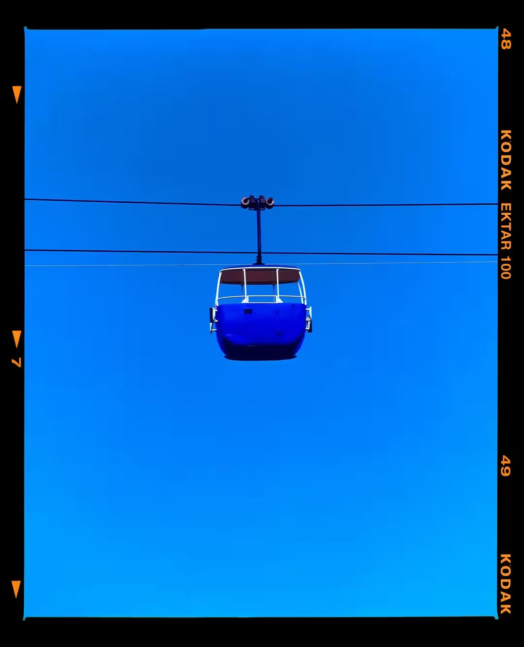 A limited edition photograph by Richard Heeps using vibrant colours, the title is Summit Cable Car (Blue)
