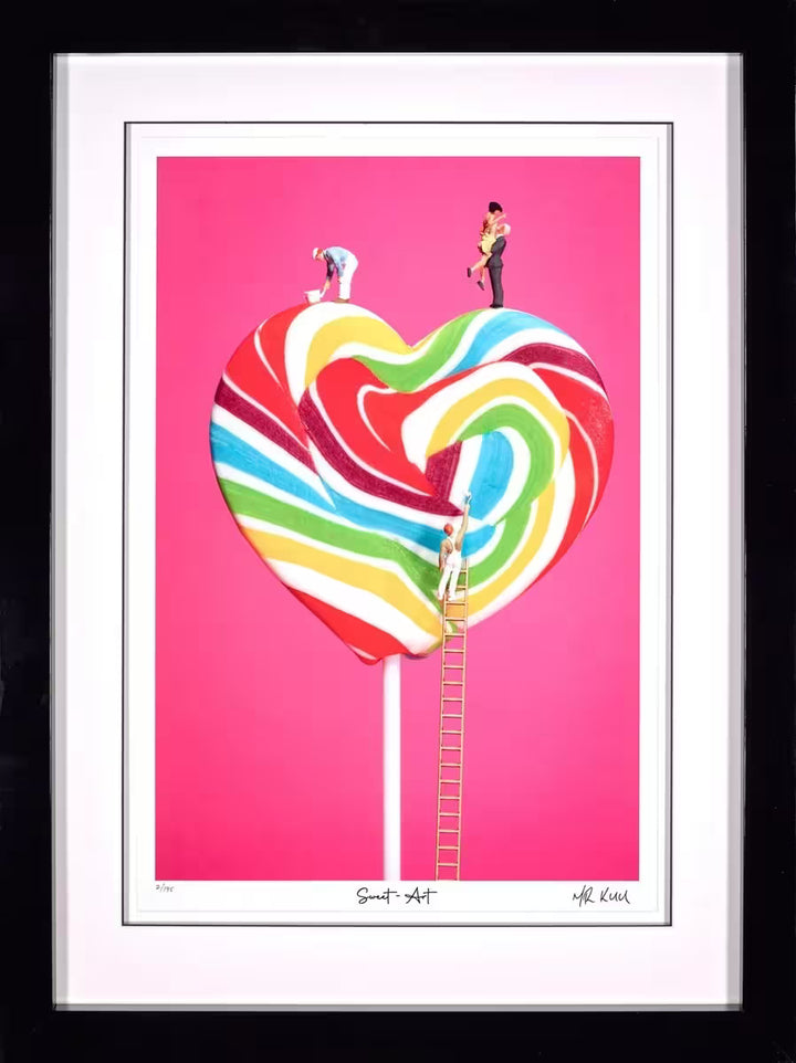 A Mr Kuu limited edition piece of a heart shaped lollipop with people painting the stripes and a couple on top, the title is Sweet Art