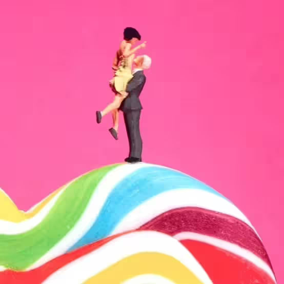 A Mr Kuu limited edition piece of a heart shaped lollipop with people painting the stripes and a couple on top, the title is Sweet Art