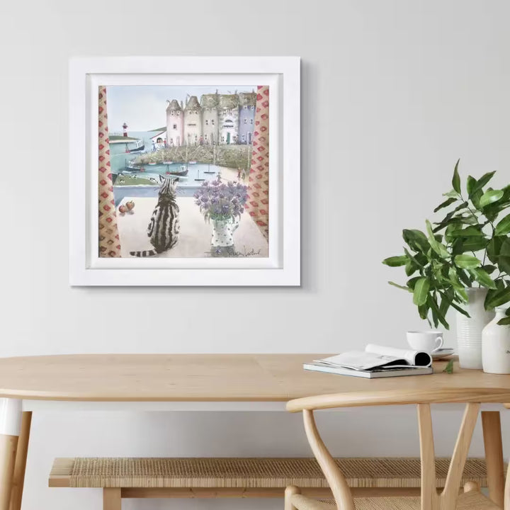 A Rebecca Lardner limited edition of a seaside town with boats, cows and people and a cat sat on a table looking down, the title is Table Manners