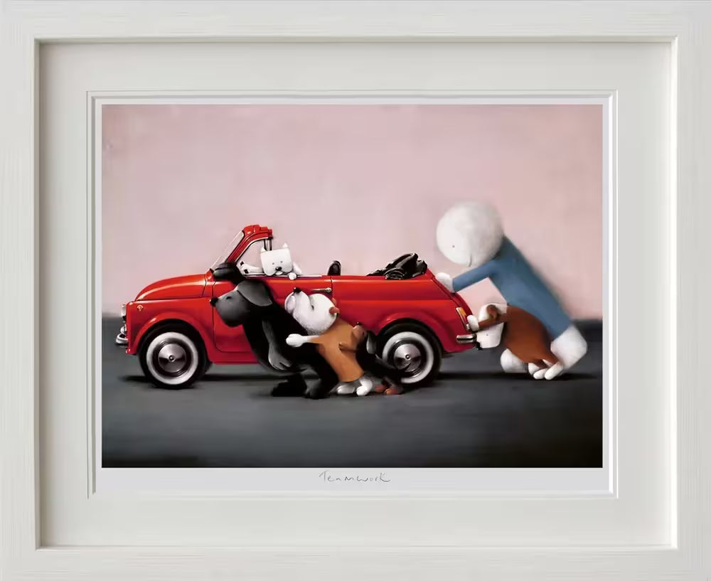 A Doug Hyde framed limited edition of a person in blue pushing a red car with four dogs helping and one more dog in the drivers seat, the title is Teamwork