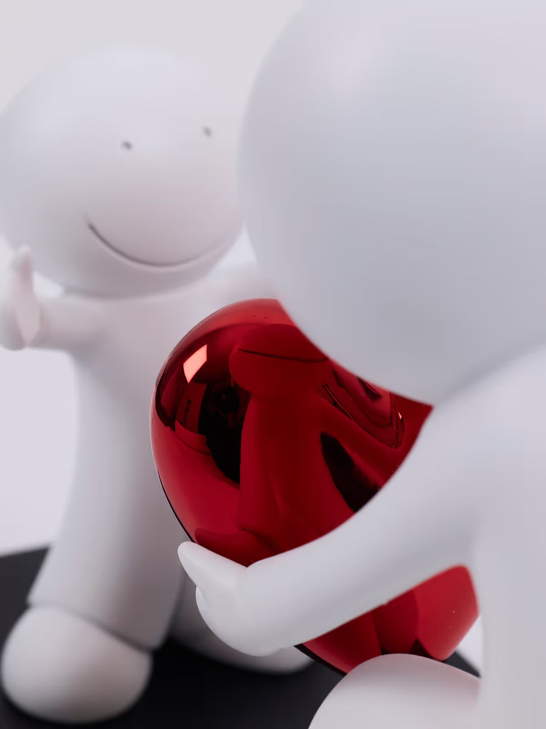 White figure holding a red heart-shaped object on a white background, the Greatest Gift by Doug Hyde