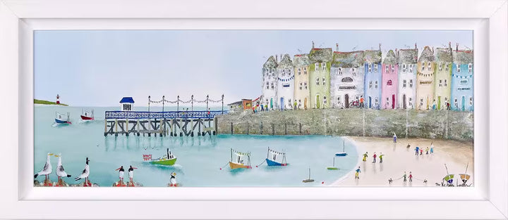 A Rebecca Lardner limited edition piece of a row of colourful houses with a pier at the end and people on the beach and boats on the sea with puffins, seagulls, and avocets on the rocks, the title is Tide and Seek