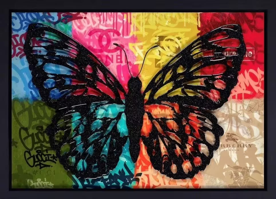 A Dan Pearce limited edition piece of a background with different fashion labels on with a black glittery butterfly over the top, the title is Wings of Love