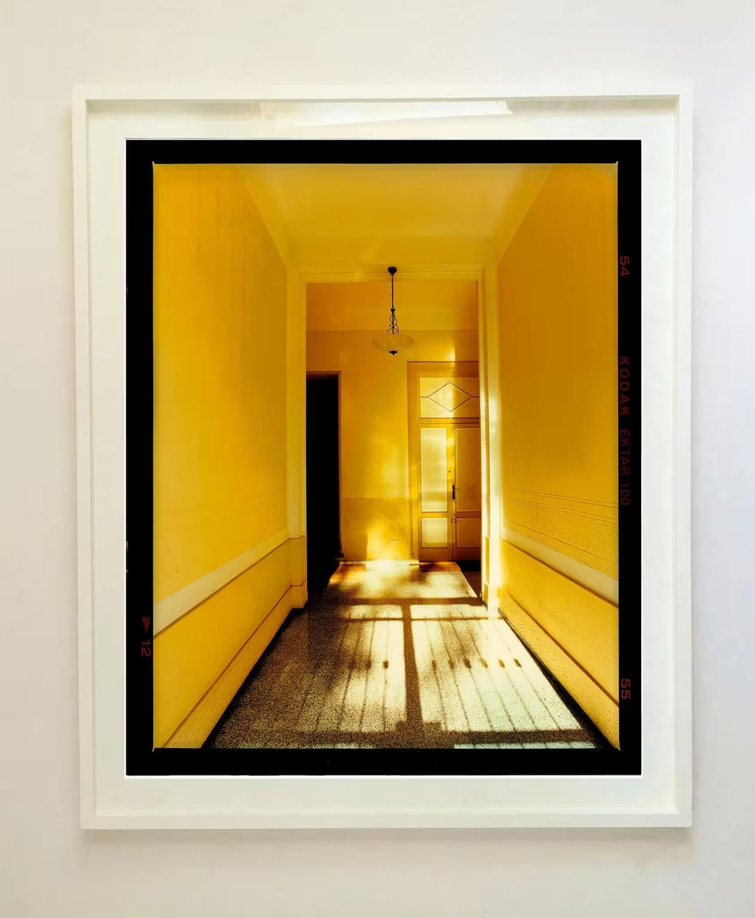 A white framed limited edition photograph by Richard Heeps using vibrant colours, the title is Yellow Corridor Day, Milan, 2019