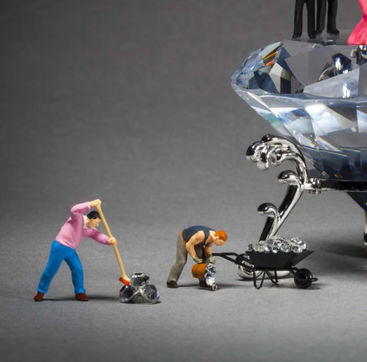Miniature figures working on a crystal object with tools on a grey background, Diamonds Are A Girl&