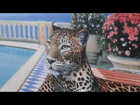 A Steve Tandy limited edition of a leopard laying on a sun bed b a sunny poolside, the title is Summer in Sorrento