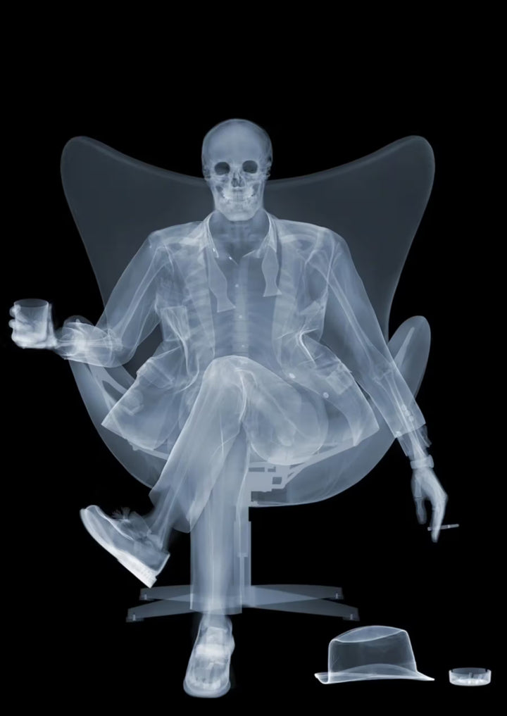 A limited edition Chromaluxe print by Nick Veasey of an X-Rayed ratpack member sat on a big chair with a drink in their hand, the title is Rat Pack